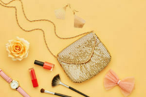 Bolsa e vários cosméticos ao redor.