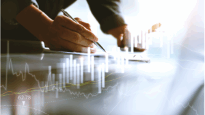 Pessoa escrevendo com caneta sobre tablet ou papel, com gráficos digitais de desempenho financeiro sobrepostos à imagem, representando análise de dados e crescimento de resultados.