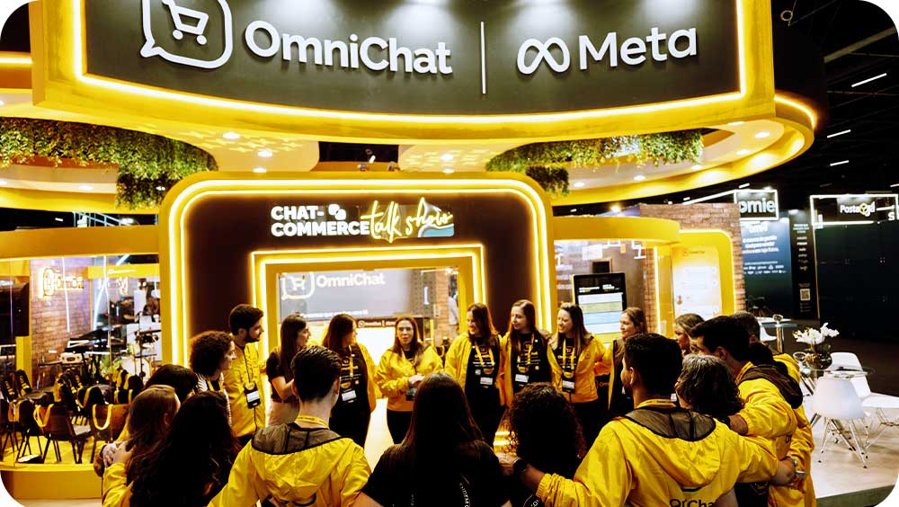 Grupo de pessoas com jaquetas amarelas participando de evento de tecnologia OmniChat